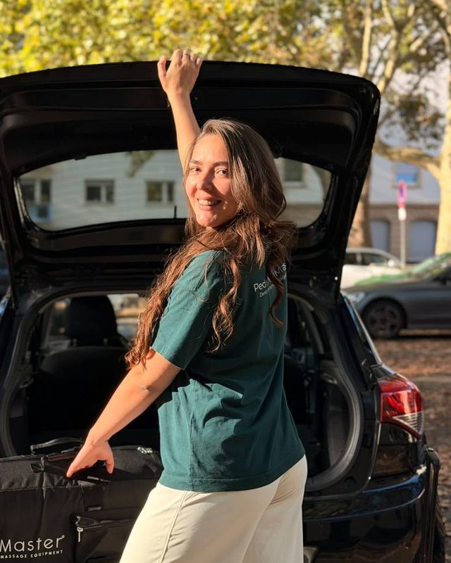 Pedra lädt ihre Massageliege aus dem Auto – so kommt sie zu Ihnen nach Hause